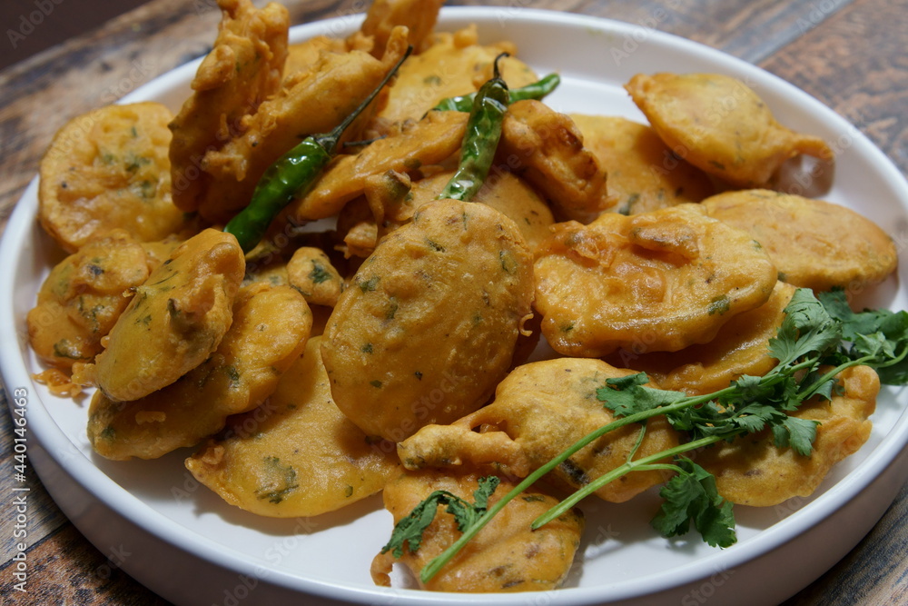 Vegan Aloo Pakora, Aloo Pakoda, Potato Fritters a thin slice of Potato dipped in Gram flour with spices and deep fried. Vegan Aloo Pakora, Aloo Pakoda, Potato Fritters a thin slice of Potato dipped in Gram flour with spices and deep fried.
