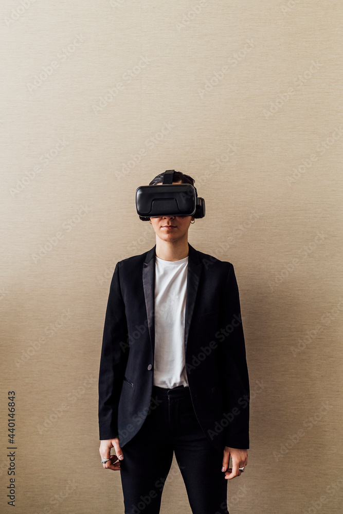 Young professional using virtual reality simulator in front of wall in office Young professional using virtual reality simulator in front of wall in office