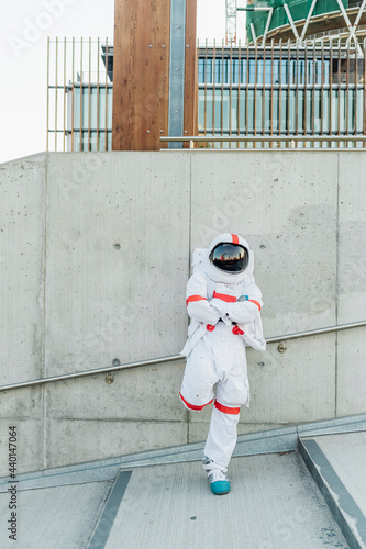 Male astronaut standing with arms crossed leaning on wall photo