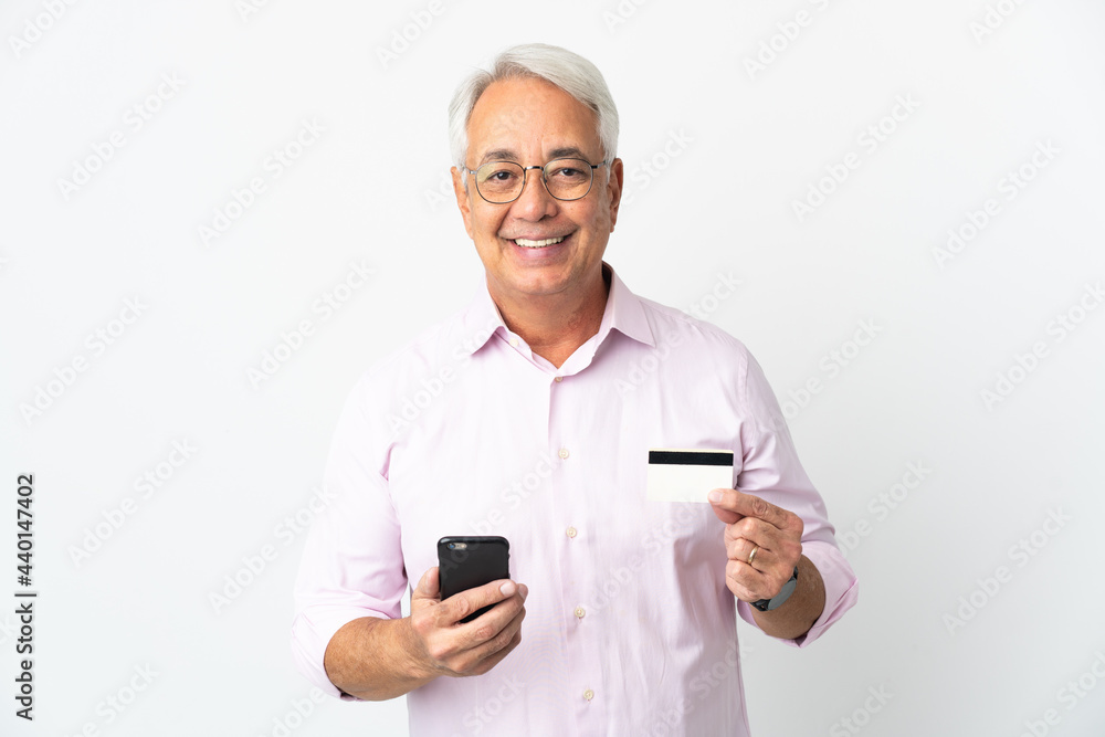 Middle age Brazilian man isolated on white background buying with the mobile with a credit card