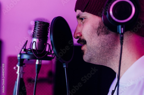 Male singer looking away while singing at studio photo