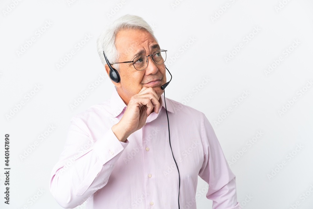 Telemarketer Middle age man working with a headset isolated on white background having doubts and thinking Telemarketer Middle age man working with a headset isolated on white background having doubts and thinking