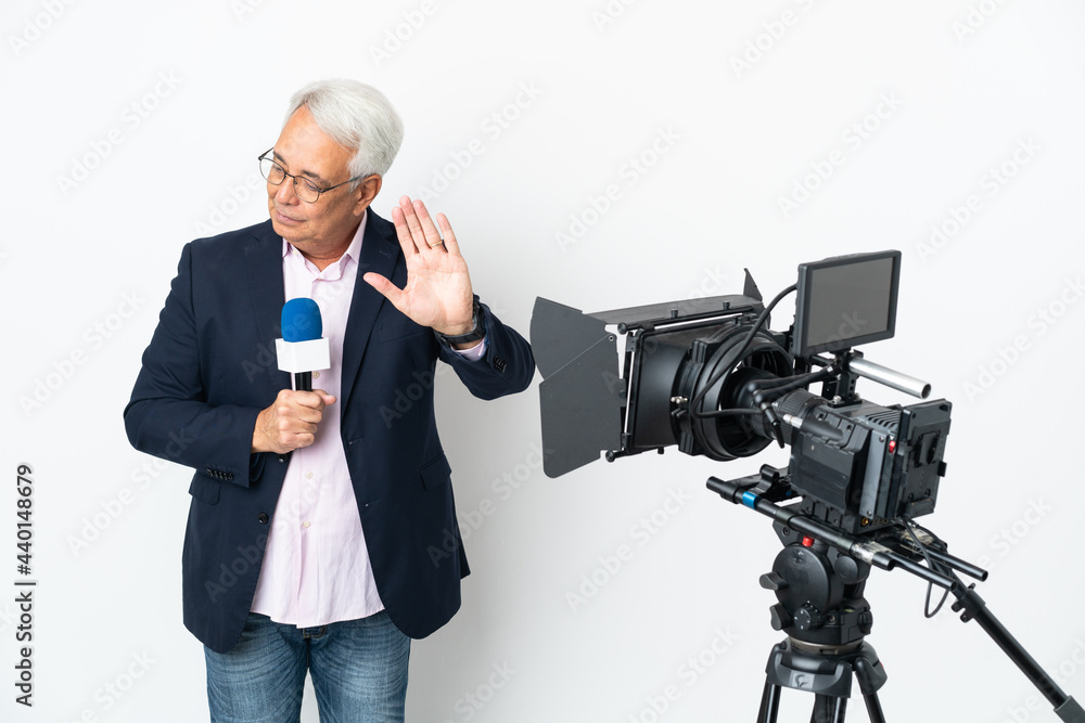 Reporter Middle age Brazilian man holding a microphone and reporting news isolated on white background making stop gesture and disappointed