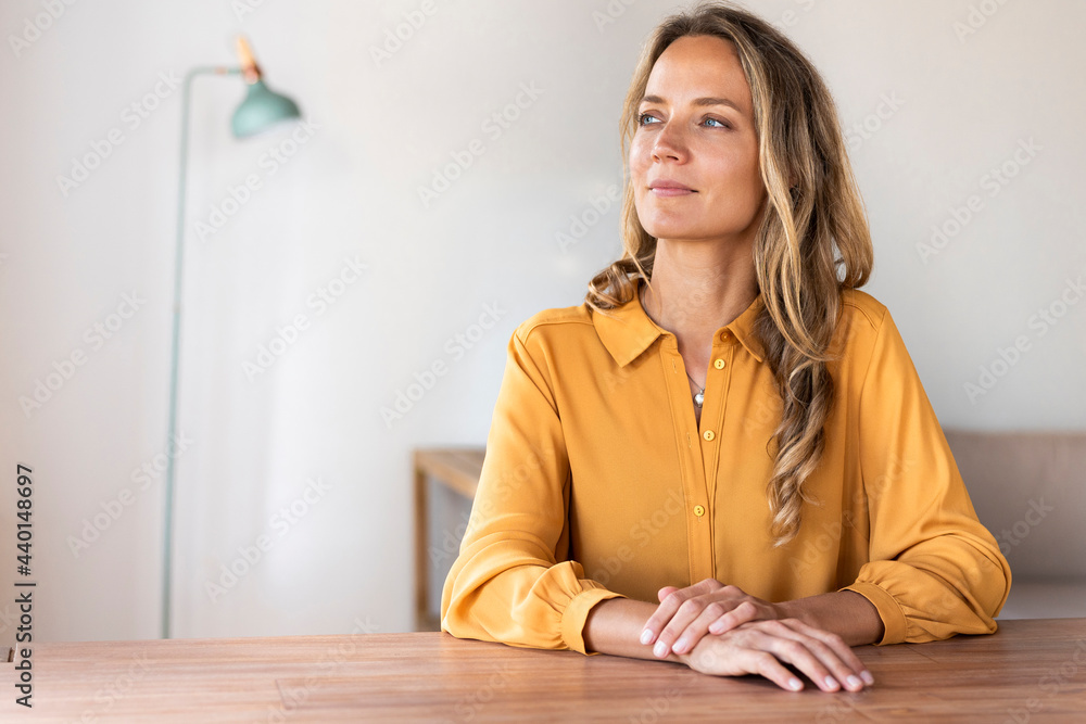 Confident blond woman looking away at home Confident blond woman looking away at home