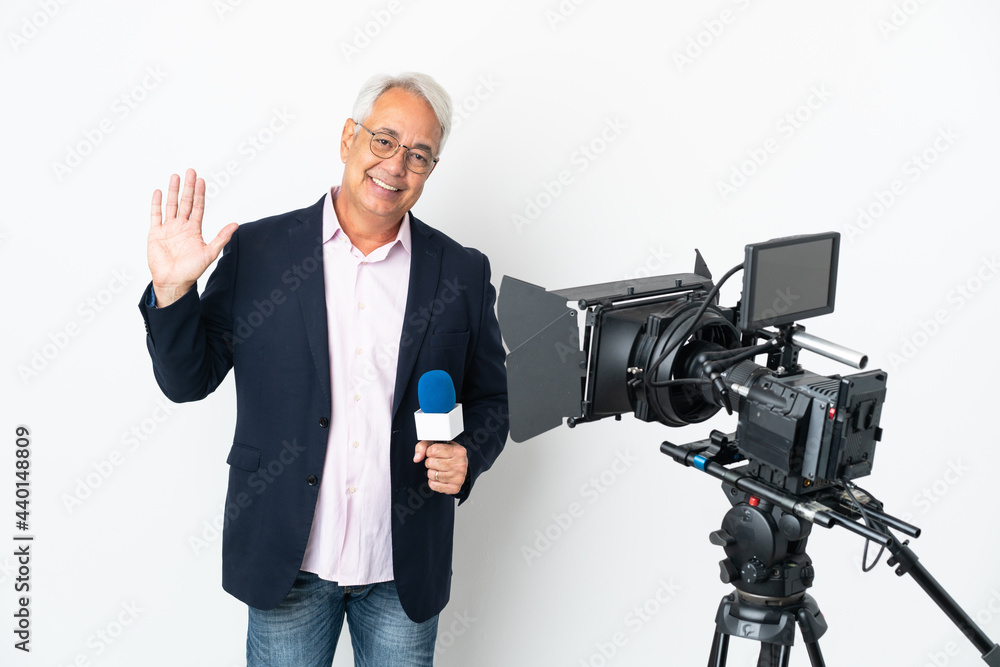 Reporter Middle age Brazilian man holding a microphone and reporting news isolated on white background saluting with hand with happy expression