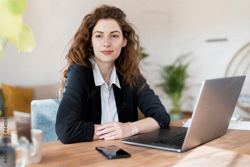 © steve brookland/Westend61 - Beautiful female professional day dreaming while sitting in front of laptop at home office © steve brookland/Westend61 - Beautiful female professional day dreaming while sitting in front of laptop at home office