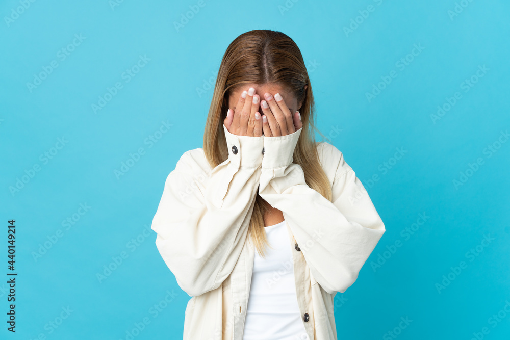 Young blonde woman isolated on blue background with tired and sick expression Young blonde woman isolated on blue background with tired and sick expression