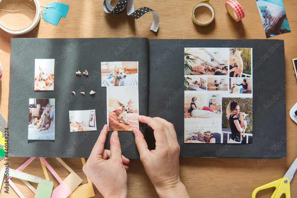 © skabarcat/Westend61 - Woman making scrapbook of pet dog on table