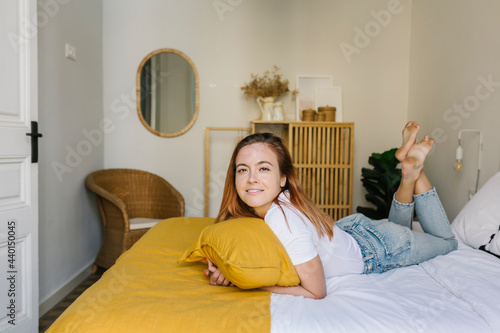 Smiling woman lying on bed at home photo