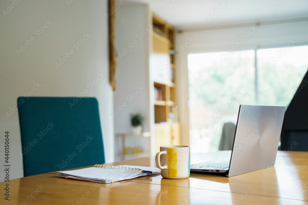 Laptop with coffee cup and book on table at home Laptop with coffee cup and book on table at home