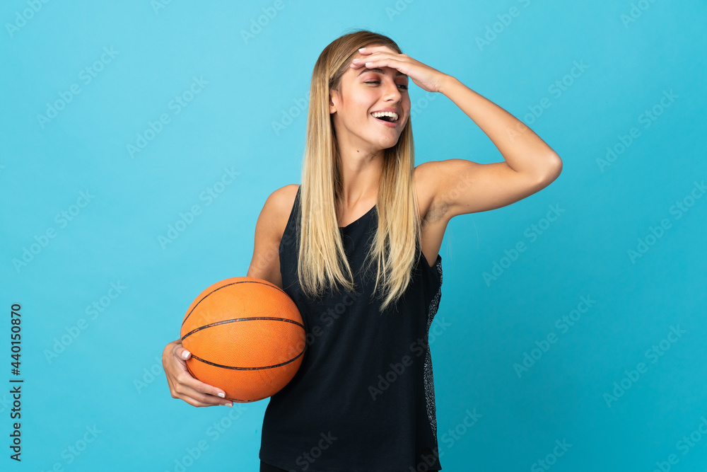 Young woman playing basketball  isolated on white background smiling a lot
