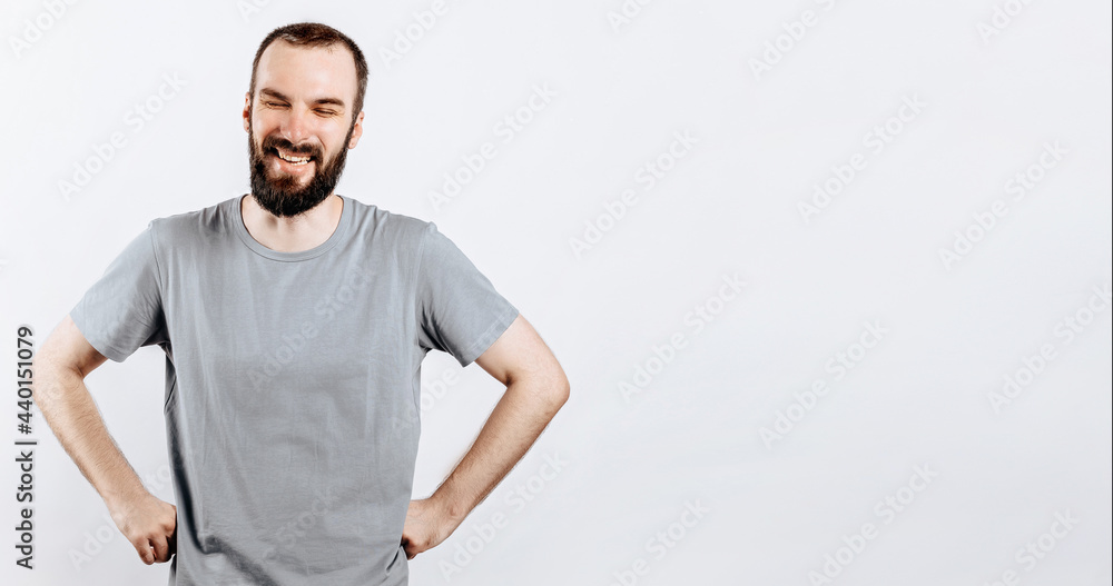 Portrait of cheerful young man smiling while looking at camera holding hands out to sides on white background with space for advertising mock up Portrait of cheerful young man smiling while looking at camera holding hands out to sides on white background with space for advertising mock up