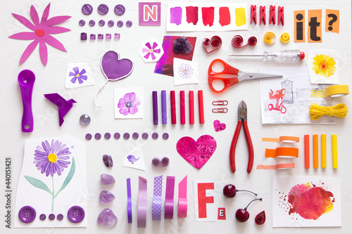 Arrangement of various tools and sewing items going from purple to red and yellow photo