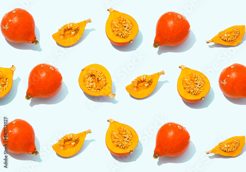 Pattern of rows of whole and halved red kuri squashes photo