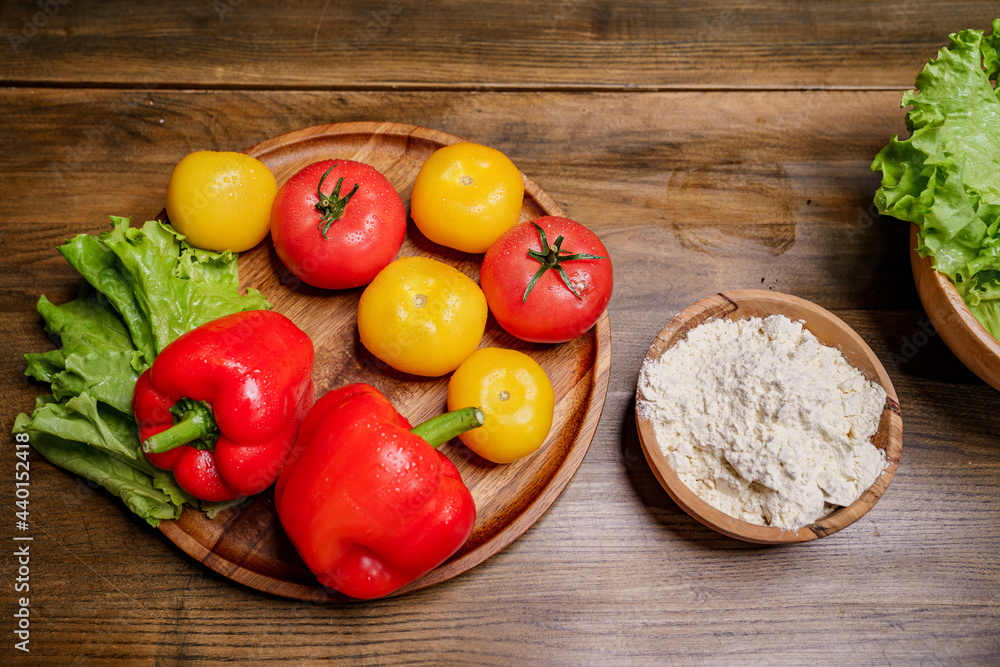 a wooden bowl of flour and vegetables on the kitchen table. a wooden bowl of flour and vegetables on the kitchen table.