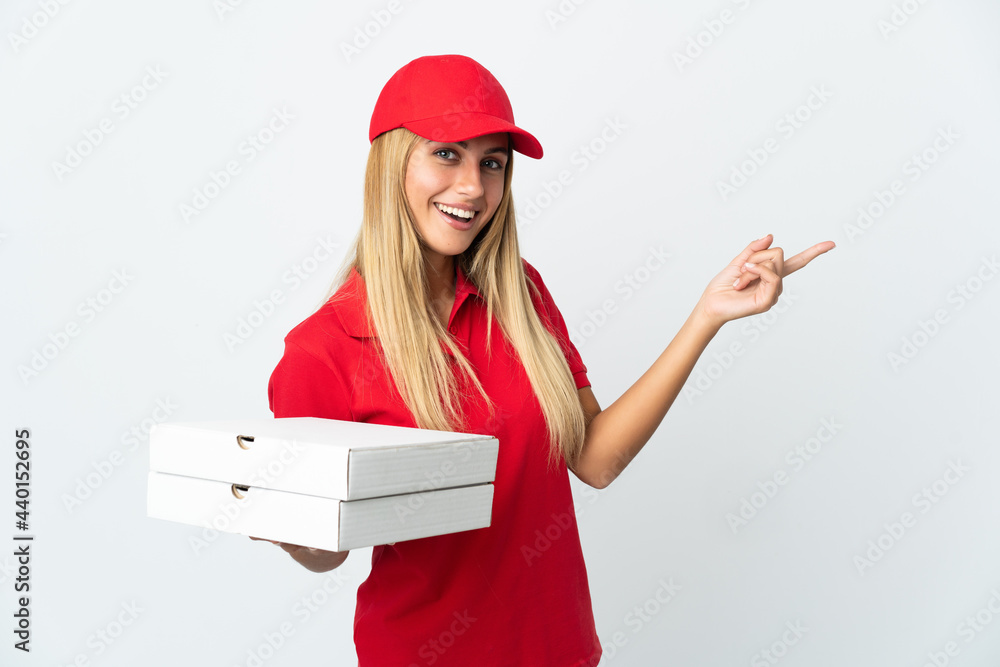 Pizza delivery woman holding a pizza isolated on white background pointing finger to the side Pizza delivery woman holding a pizza isolated on white background pointing finger to the side
