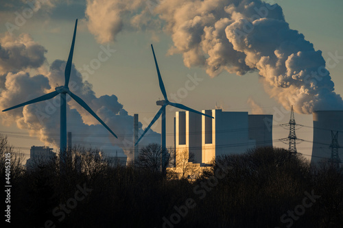 Germany, North Rhine Westphalia, Neurath, Wind turbines and lignite power station at sunset