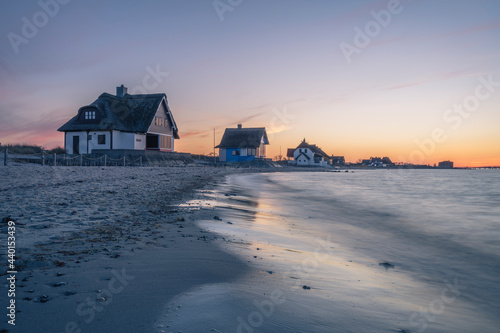 Germany, Schleswig-Holstein, Heiligenhafen, Beachside villas standing along shore of Graswarder headland at dusk photo