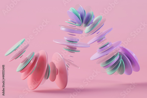 Three dimensional render of pastel colored rings floating against pink background photo
