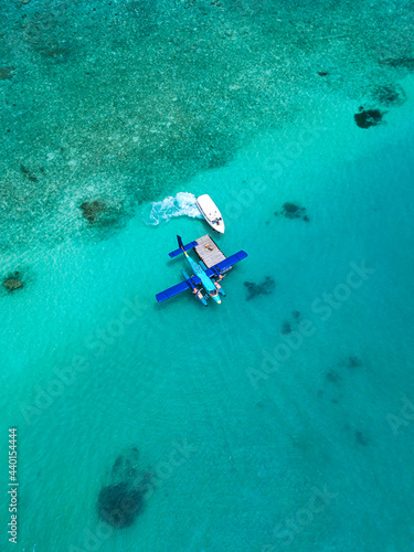 Aerial view of motorboat approaching hydroplane floating in turquoise water of Male Atoll photo