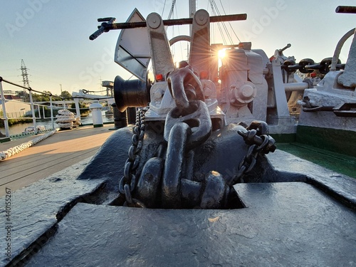 Anchor chain on board the ship. Bright rays of the sun make their way onto the deck of the ship.