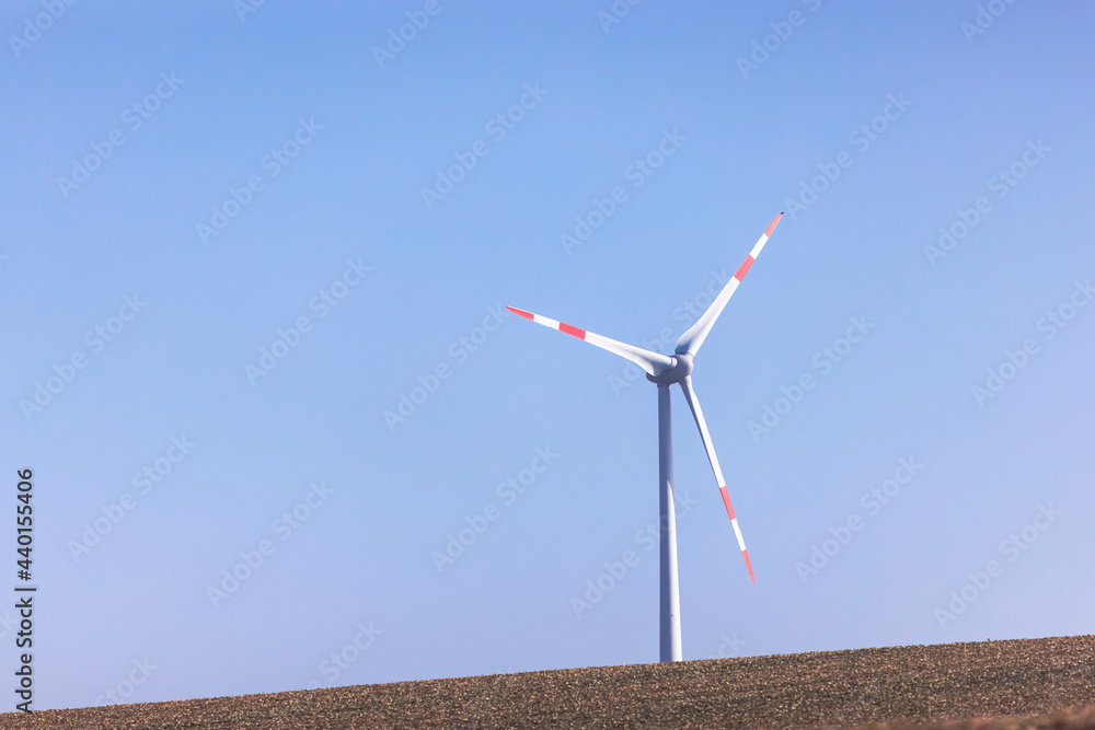 Wind turbine standing against clear blue sky Wind turbine standing against clear blue sky