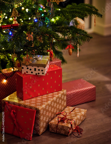 Wrapped gifts in front of Christmas tree at home photo