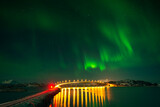 Norway, Tromso, Sommaroy, Northern lights over illuminated bridge