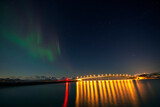 Norway, Tromso, Sommaroy, Aurora Borealis over illuminated bridge