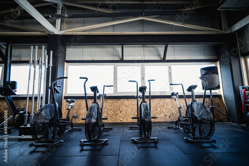 Row of exercise bikes standing in empty gym