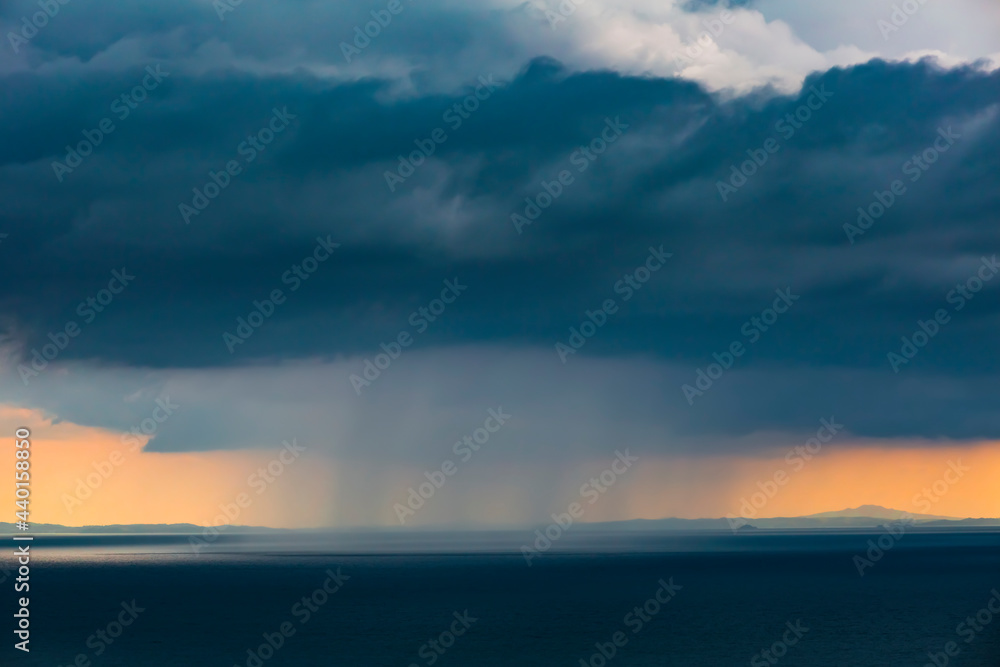 Gray rain clouds over Pacific Ocean at dusk Gray rain clouds over Pacific Ocean at dusk