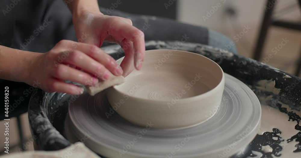 Hands of a master potter working on a potter's wheel, forming a bowl of clay. Close-up, slow motion Hands of a master potter working on a potter's wheel, forming a bowl of clay. Close-up, slow motion