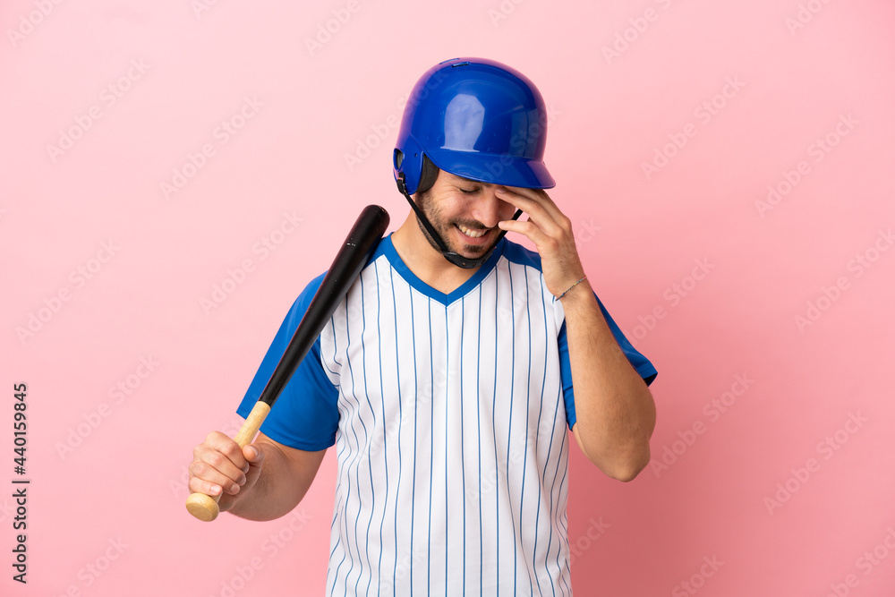 Baseball player with helmet and bat isolated on pink background laughing