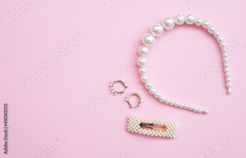 White Pearl Hair clips and earring on pink background, group of trendy accessories. Copy space