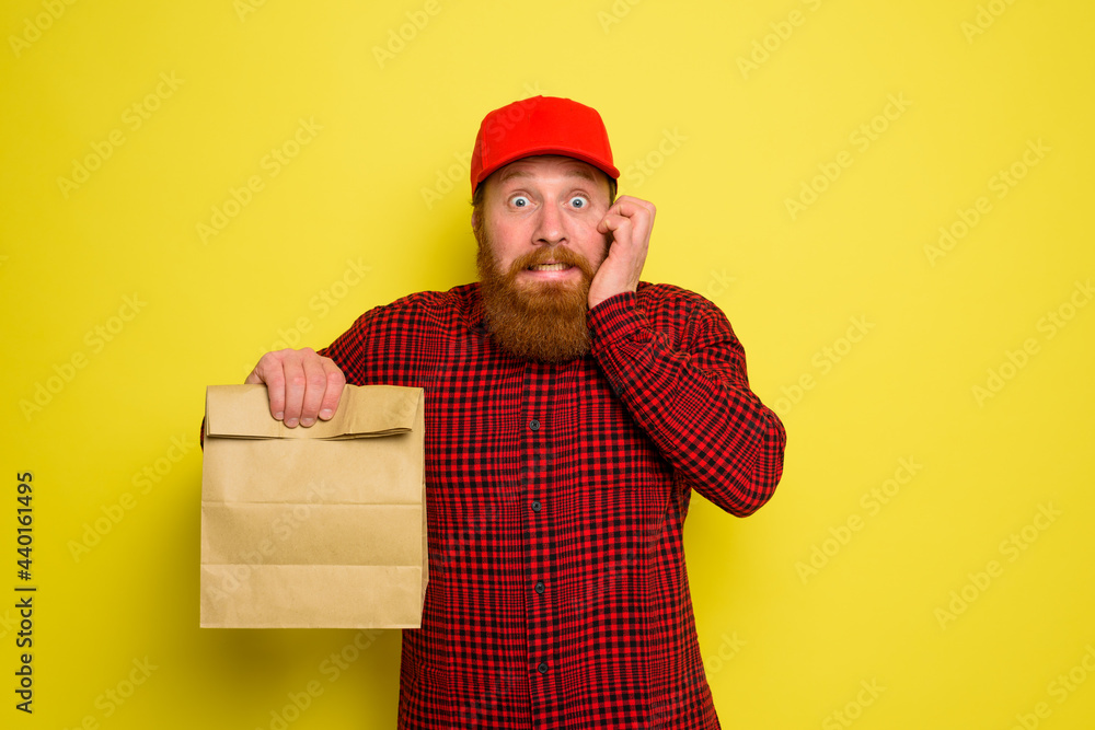 Delivery man with hat and beard has an afraid expression