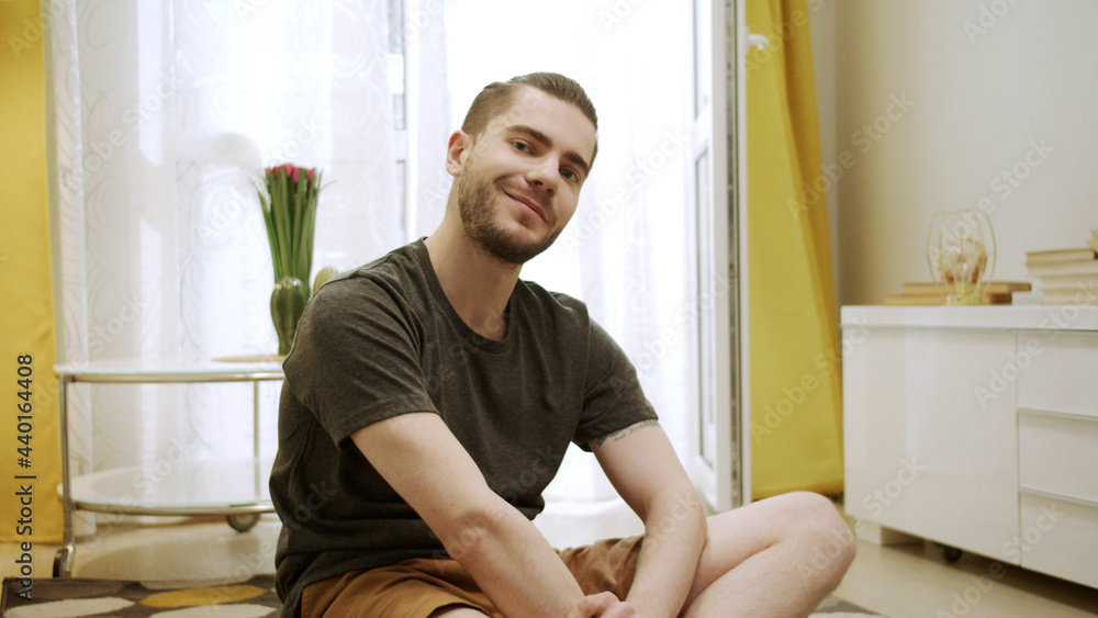 A young man is looking to the camera and smiling A young man is looking to the camera and smiling