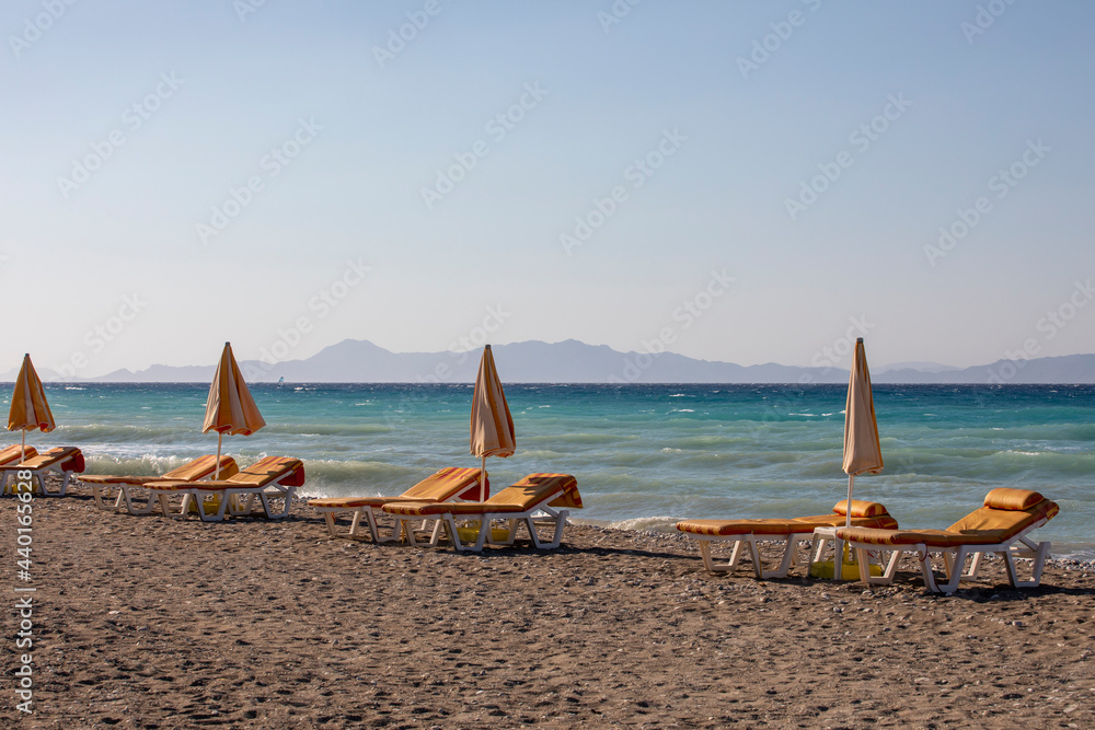 sandy beach with umbrellas in the afternoon, season opening, horizontal.. sandy beach with umbrellas in the afternoon, season opening, horizontal..