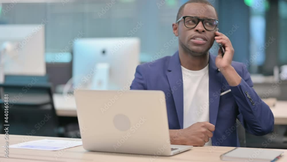 African Businessman Talking on Smartphone in Office African Businessman Talking on Smartphone in Office
