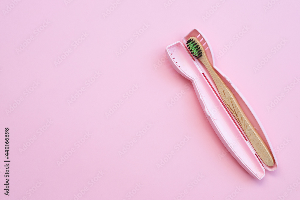 Toothbrush in a plastic case on pink background - obrazy, fototapety, plakaty 