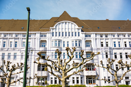 Beautiful white residential building with a brown roof in Oberkassel, Dusseldorf, Germany photo