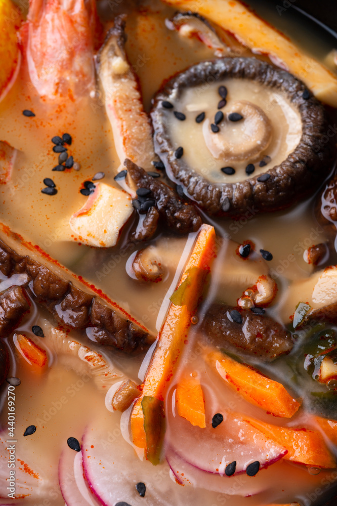 miso soup with mussels, shrimps , shiitake mushrooms and vegatables. macro shot. flat lay