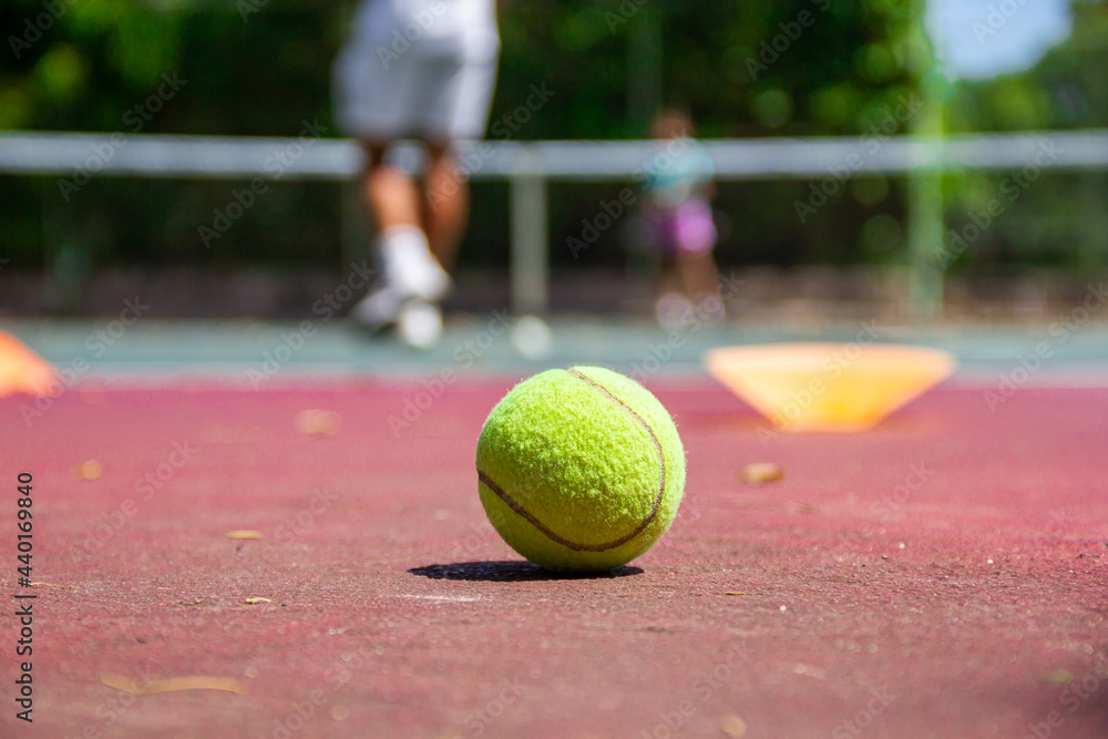 Jugador de tenis en acción en la pista de tenis (enfoque selectivo, foco en el baile en primer plano).