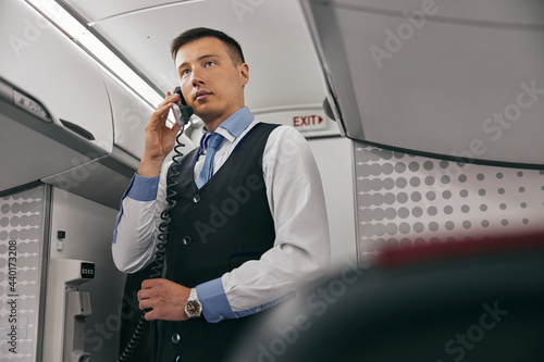 Flight attendant talk on board phone in airplane