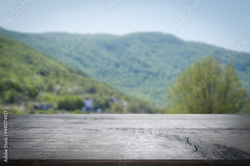 Closeup shot of a wooden table over blurred park nature background