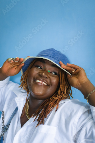 portrait of a woman laughing holding her hat.