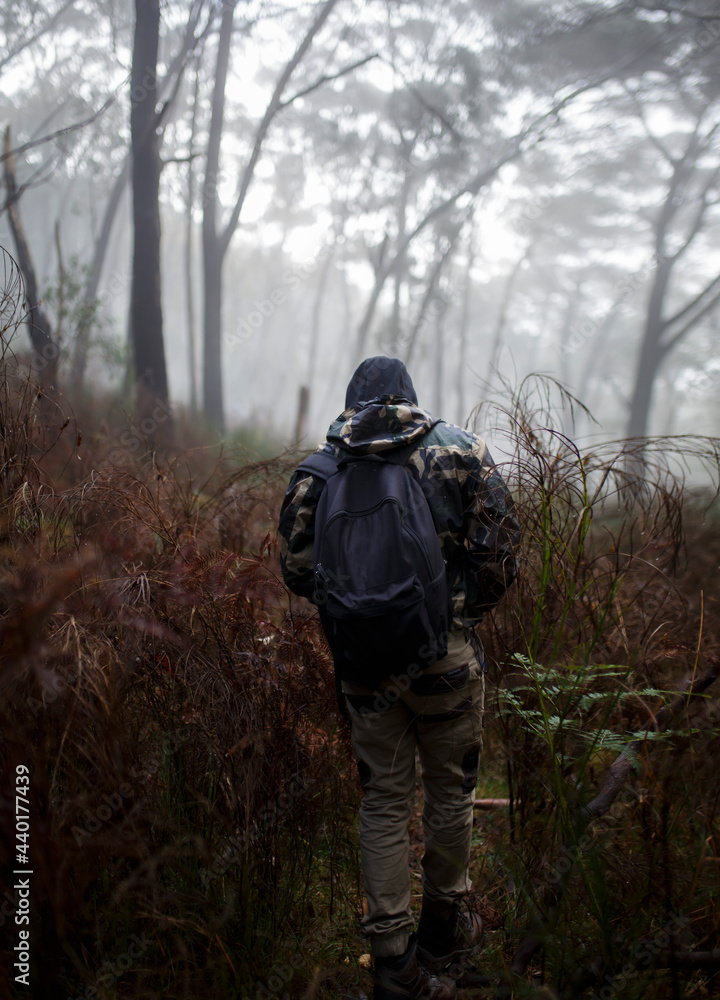 bag packer hiking through a misty, foggy forest in Adelaide, South Australia in the cold days of winter