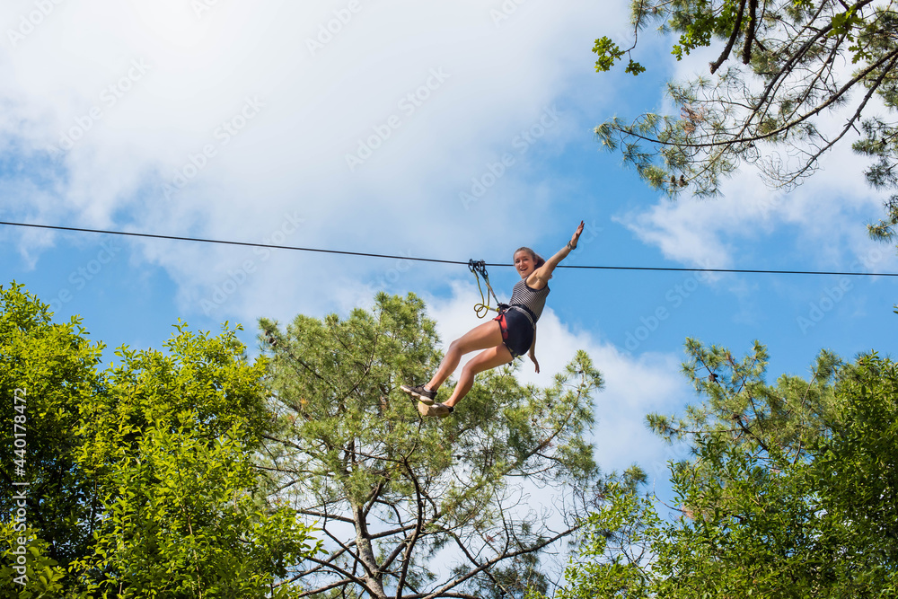pretty young woman in an extreme tree climbing course - obrazy, fototapety, plakaty 