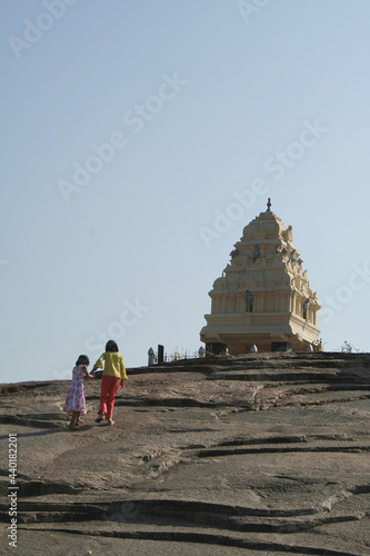 Sisters climbing rock bed to reach Kempegowda Tower at Lal Bagh, Bangalore, India, Asia photo