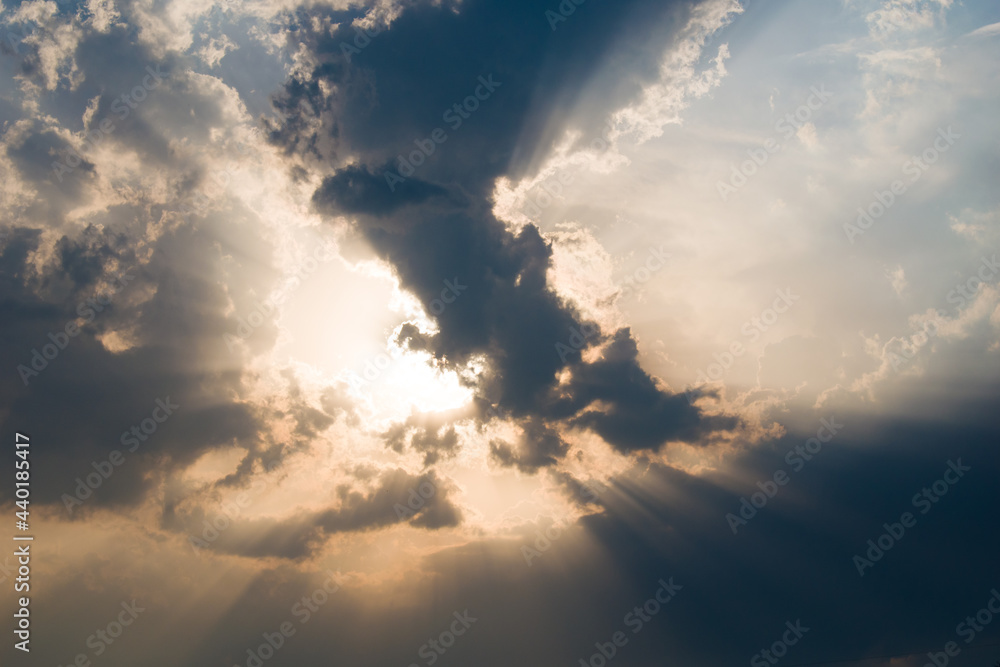 Evening time picture of sun rays penetrating through big cloud