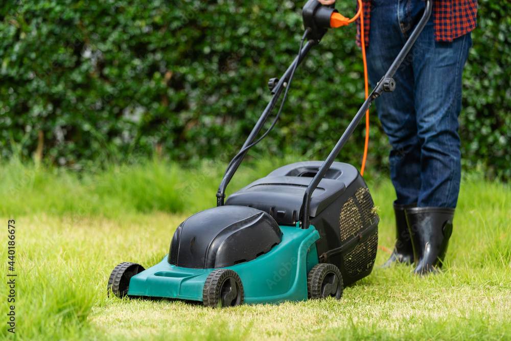 worker using a lawn mower cutting grass worker using a lawn mower cutting grass